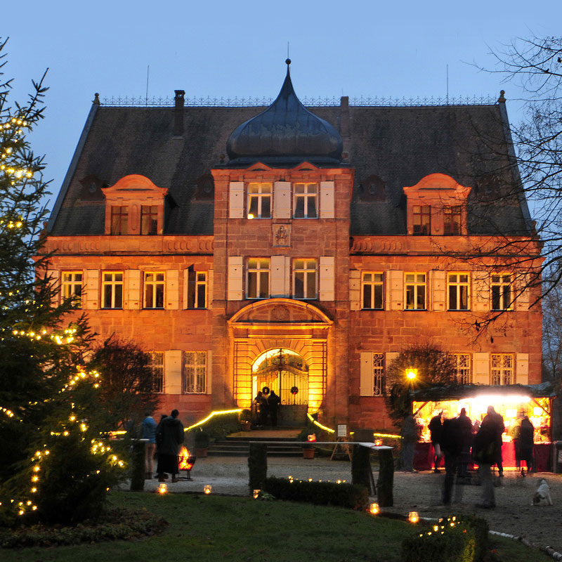 Frontansicht des weihnachtlich beleuchteten Schloss Dürrenmungenau in der Abenddämmerung