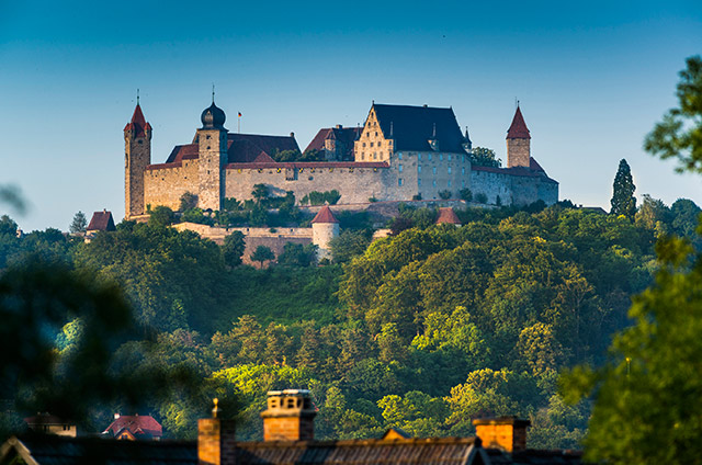 Burg auf einer grün bewachsenen Anhöhe