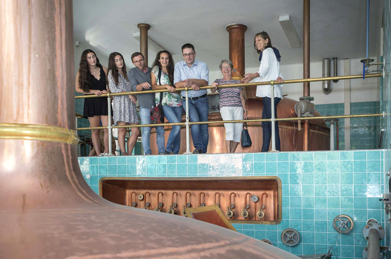 Personen stehen in der Stadtbrauerei Spalt zwischen Kupferkesseln