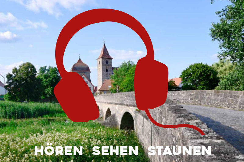 Hören, sehen, staunen - stilisierter Kopfhörer auf einem Foto einer Steinbrücke und zwei Türmen